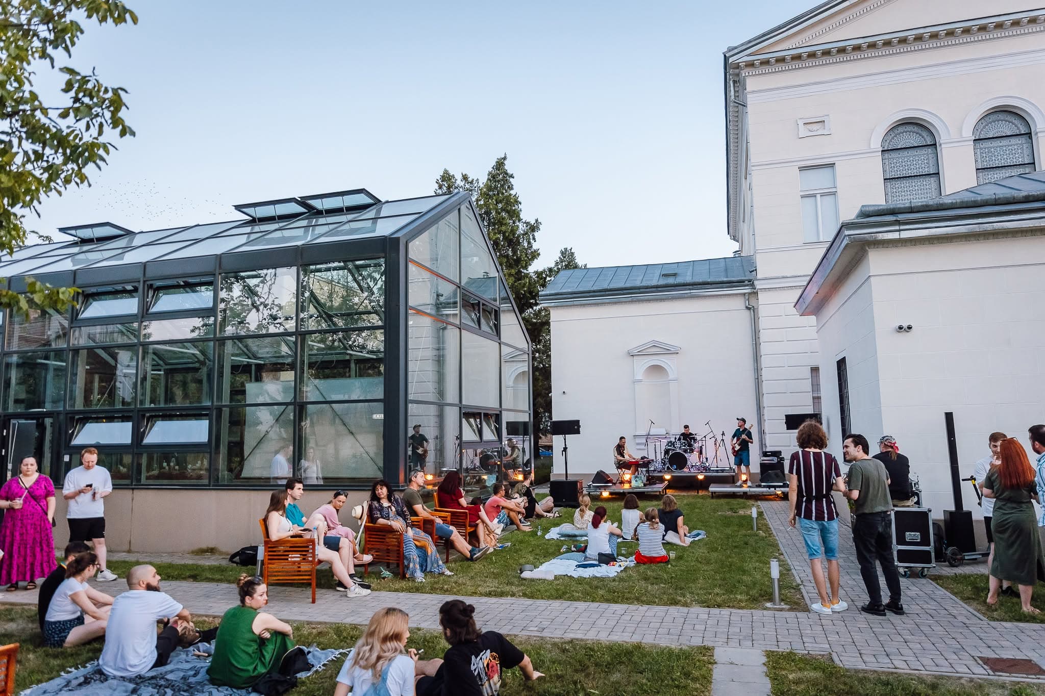 Public pe iarbă la un concert în grădina muzeului