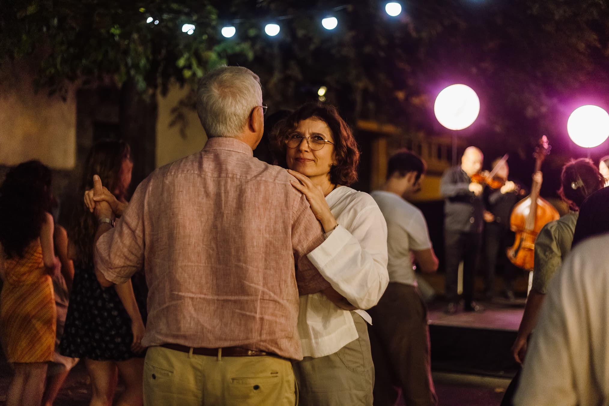 Doi oameni dansând în fața scenei